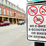 New signs on Main Street: "No E-bikes, E-Scooters or Bikes on Sidewalk"